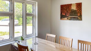 Ein Essbereich mit Tisch, Stühlen und einem Bild an der Wand.
