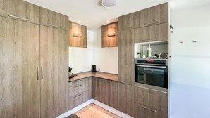 Eine moderne Küche mit Holzausstattung, Backofen und Arbeitsplatte.