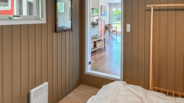 A bedroom with a bed, a radiator, a window, and a door leading to an outdoor area. - 2 bedroom stunning home in Vordingborg (Vordingborg)