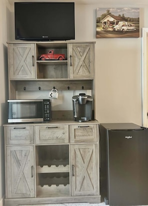 A kitchen with a microwave, coffee maker, and a refrigerator.