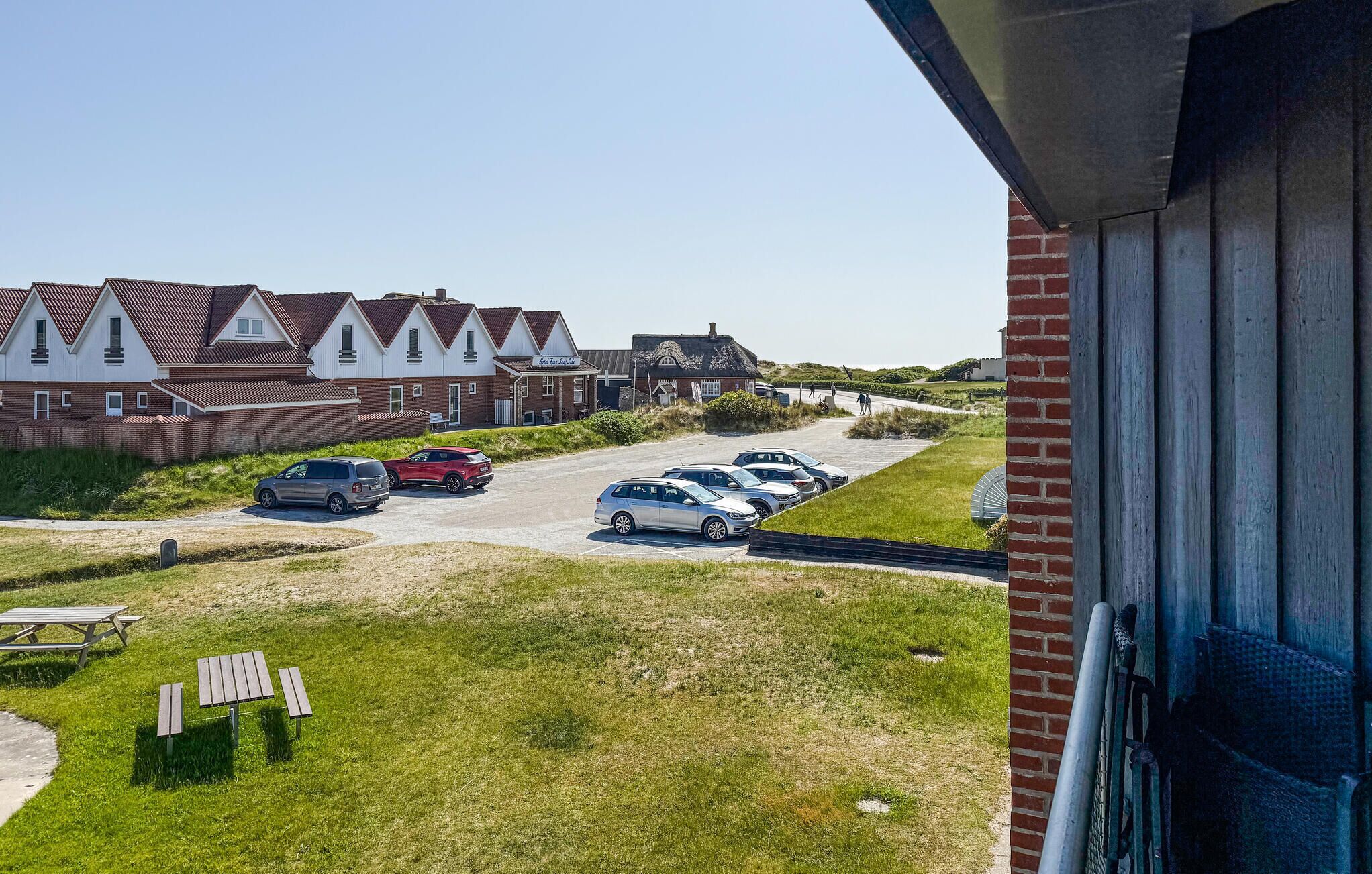 Un quartier résidentiel avec des maisons, un parking et un terrain herbeux.
