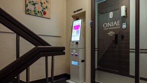 A hotel entrance with a digital check-in kiosk, a staircase, and a door with the hotel name. - ONJAE STAY SEONGSU (Seoul)