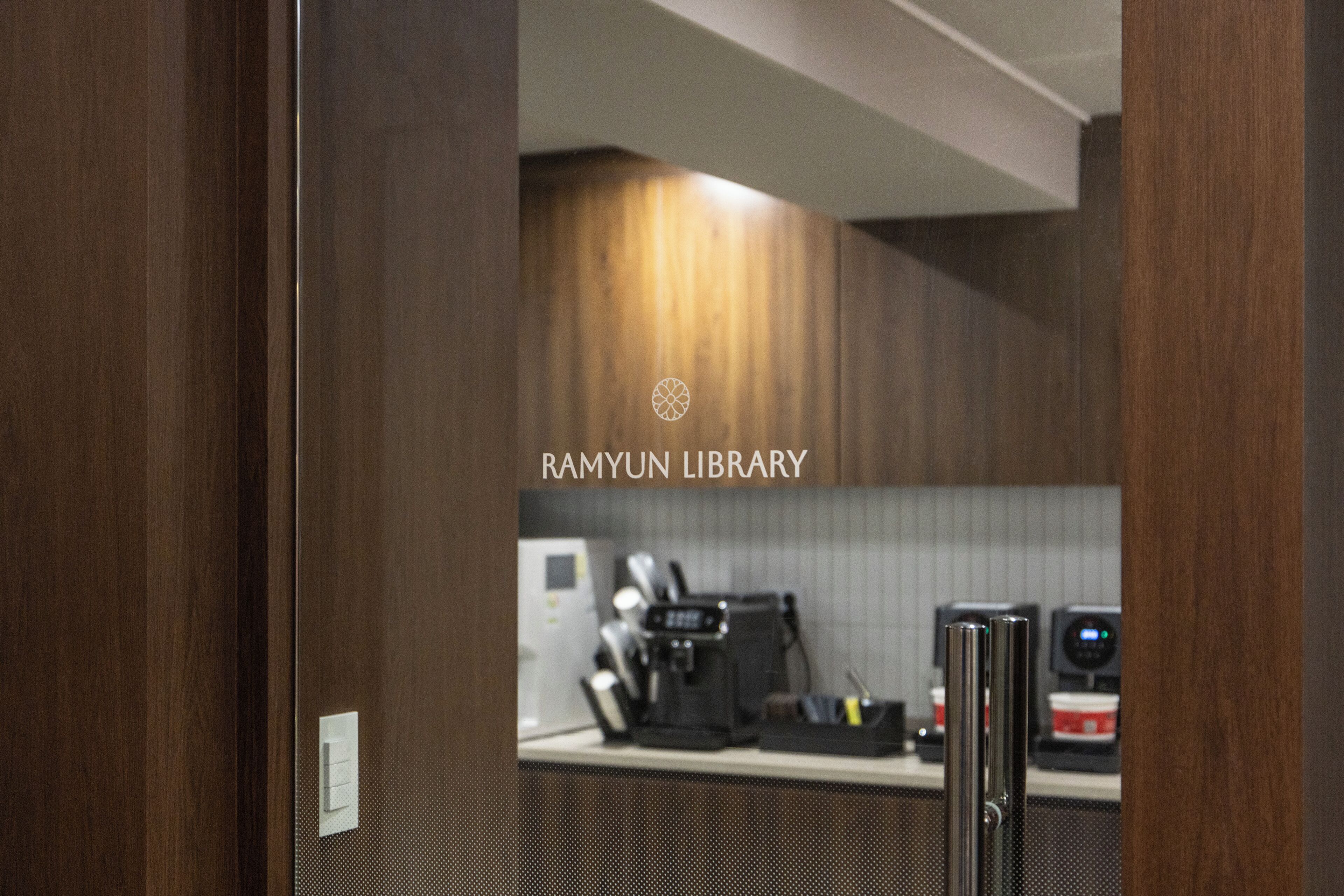 A modern kitchen with a coffee machine, a microwave, and a refrigerator.