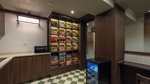 A checkered floor, a microwave, a vending machine, and a wall with a sign reading 'RAMYUN LIBRARY'. - ONJAE STAY SEONGSU (Seoul)