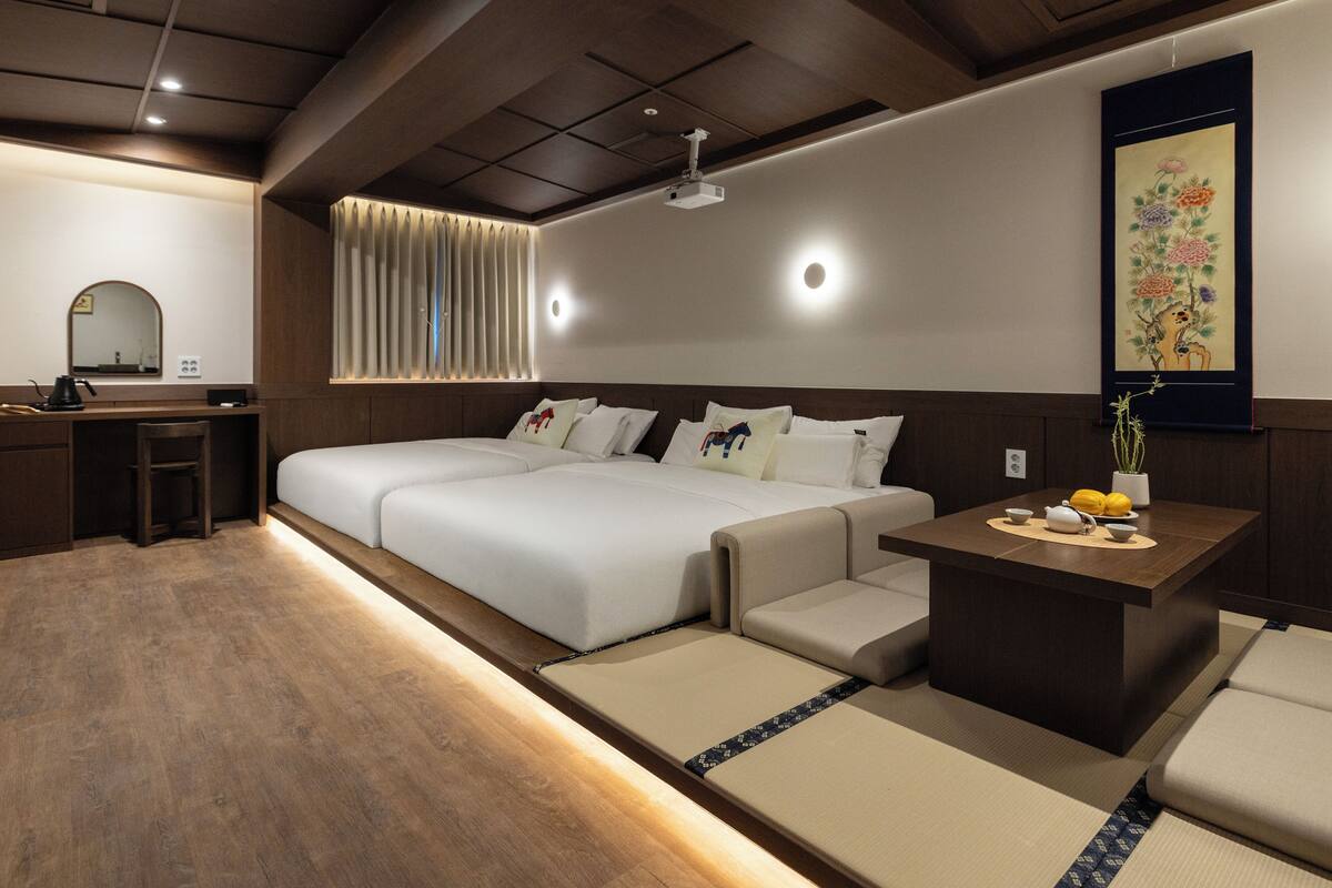 Una habitación de hotel moderna con una cama grande, un escritorio y un pequeño rincón de estar.