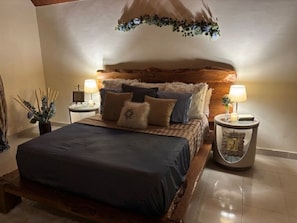 Una camera da letto con un letto di legno, due comodini con lampade e un pannello decorativo a parete.