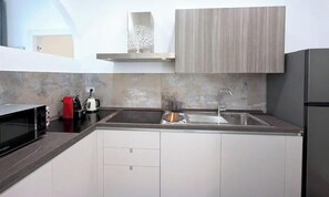 Eine moderne Küche mit Mikrowelle, Wasserkocher und Spüle.
