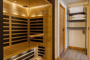 Ein begehbarer Kleiderschrank mit Holzböden und einem Metallständer für Kleidung.