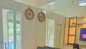 Ein modernes Wohnzimmer mit einem dunkelgrauen Sofa, einem großen Spiegel und einem Fernseher.