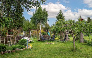 Ein Garten mit Bäumen, einer Schaukel und einem kleinen Gartenhaus.