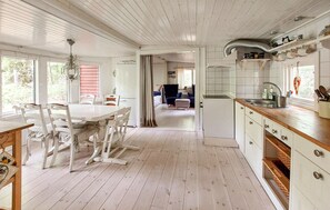 Eine geräumige Küche mit Essbereich, Holzböden und Blick zum Wohnzimmer.