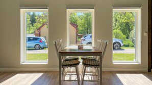A dining area with a table and chairs, large windows with a view of parked cars and greenery outside. - Awesome home in Reftele with WiFi (Reftele)