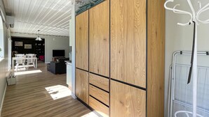 A spacious room with wooden flooring, a large wardrobe, a dining area with chairs and a table, and a television. - Awesome home in Reftele with WiFi (Reftele)