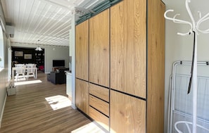 A spacious room with wooden flooring, a large wardrobe, a dining area with chairs and a table, and a television. - Awesome home in Reftele with WiFi (Reftele)