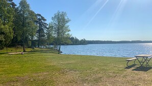 A lakeside park with picnic tables, a swing set, and a grassy area. - Awesome home in Reftele with WiFi (Reftele)