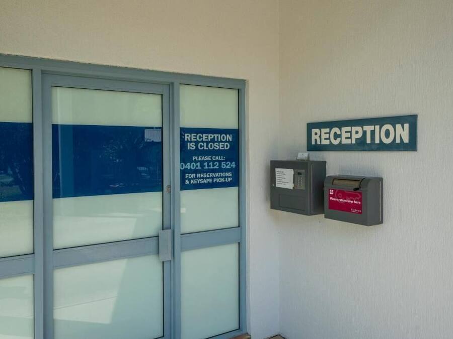 A reception area with a closed sign, a phone, and a key safe.