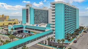 Un hotel con un llamativo letrero 'LANDMARK', un amplio estacionamiento y vista al océano.