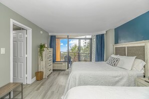 Un dormitorio con cama, cómoda, ventana con cortinas y vistas al exterior.