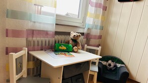 A child's room with a white desk, a teddy bear, a green pencil case, and a soccer ball. - Pension Merkle (Ichenhausen)