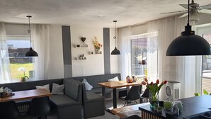 A modern interior with a dining area, seating, and a view of the outdoors. - Pension Merkle (Ichenhausen)