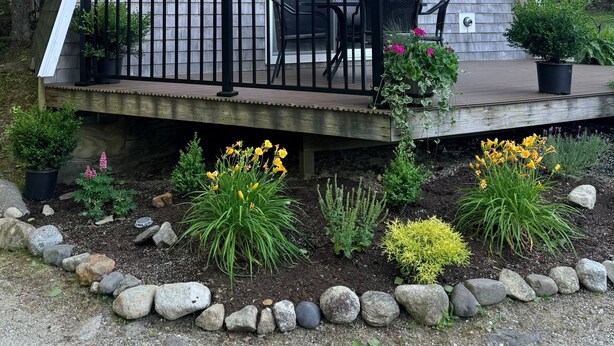 A triangular-shaped house with a deck, outdoor seating, and a garden with rocks and plants. - Four Lanterns - NEW! 4 Houses in Blue Hill (Blue Hill)