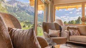 A cozy living room with a large window offering a mountain view.