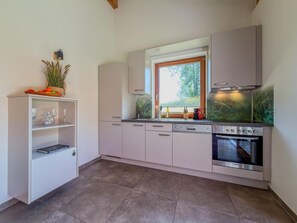 A modern kitchen with white cabinets, a built-in oven, and a window with a view of greenery. - Chalet with sauna near Nassfeld-Pressegger See (Hermagor-Pressegger See)