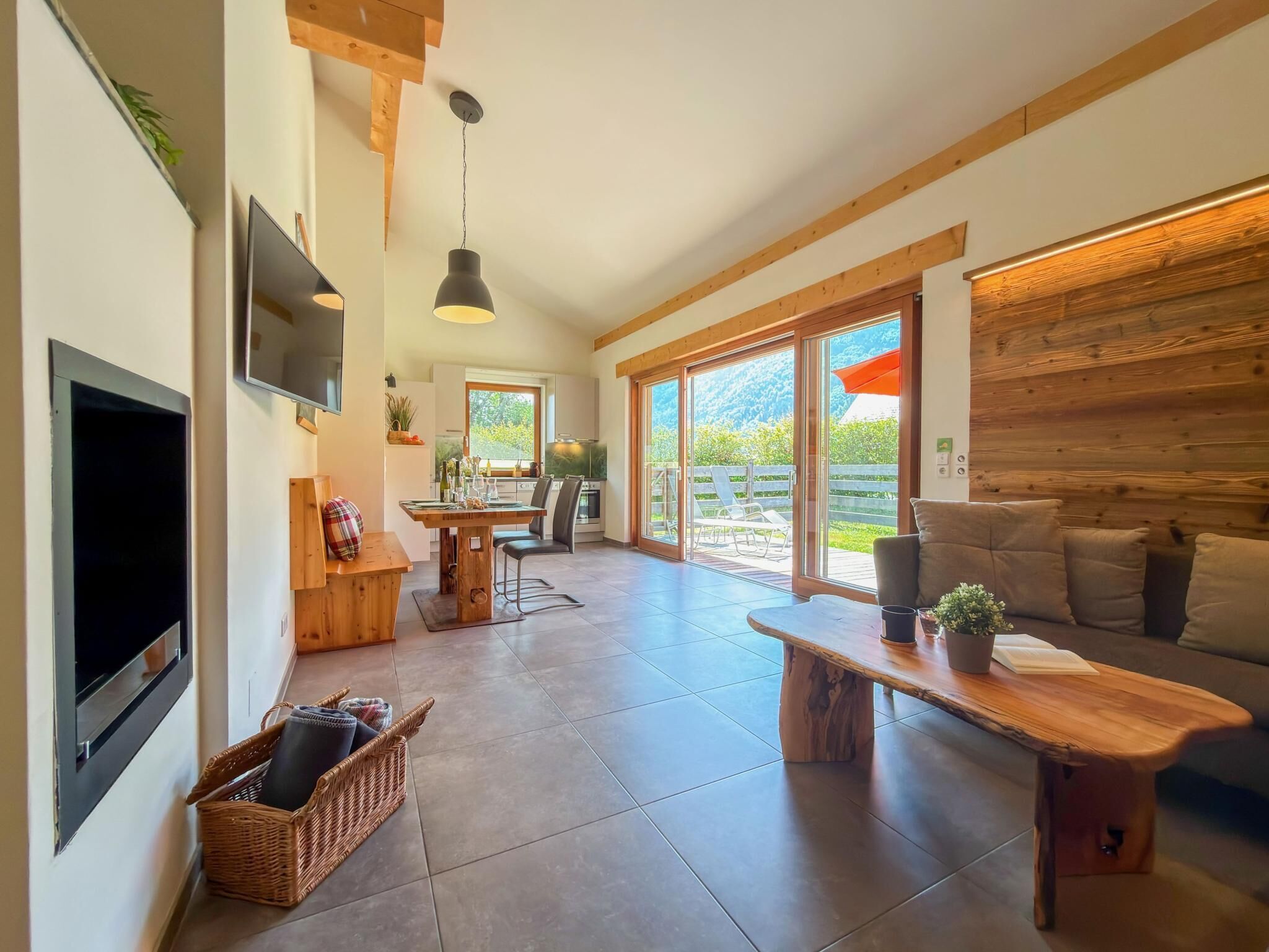 A spacious living area with a television, a dining table, and a sofa.
