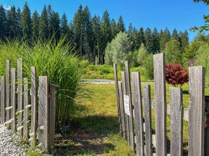 A wooden fence with a sign, surrounded by greenery and trees. - Chalet with sauna near Nassfeld-Pressegger See (Hermagor-Pressegger See)