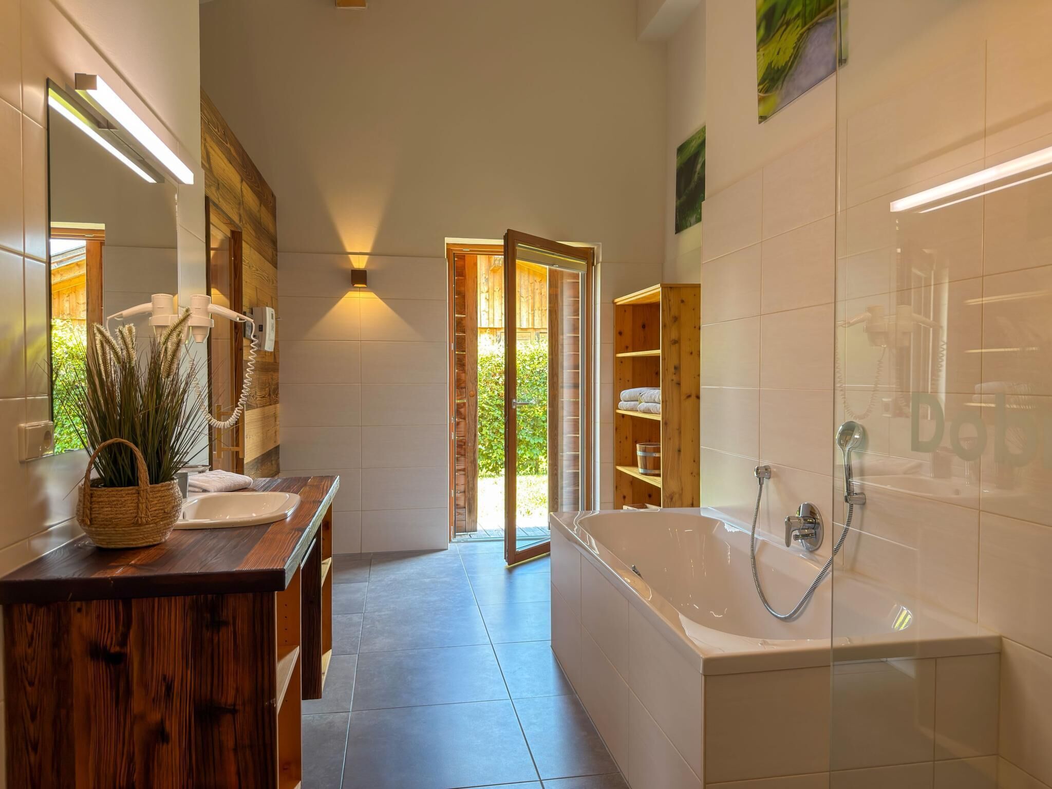 Ein modernes Badezimmer mit einem Holzwaschtisch, einer großen Badewanne und einer Duschkabine.