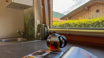 Eine Küche mit Fensterblick, einem Wasserkocher und einer Speisekarte.
