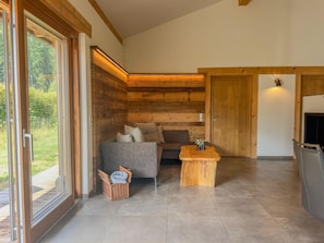 A modern living room with a sofa, a coffee table, and a fireplace. - Chalet with sauna and garden near Pressegger See (Hermagor-Pressegger See)