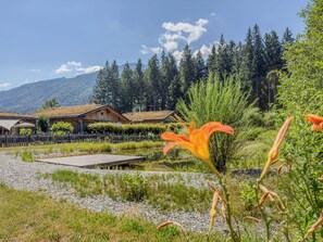 A lakeside hotel with wooden cabins, a dock, and a forested mountain backdrop.