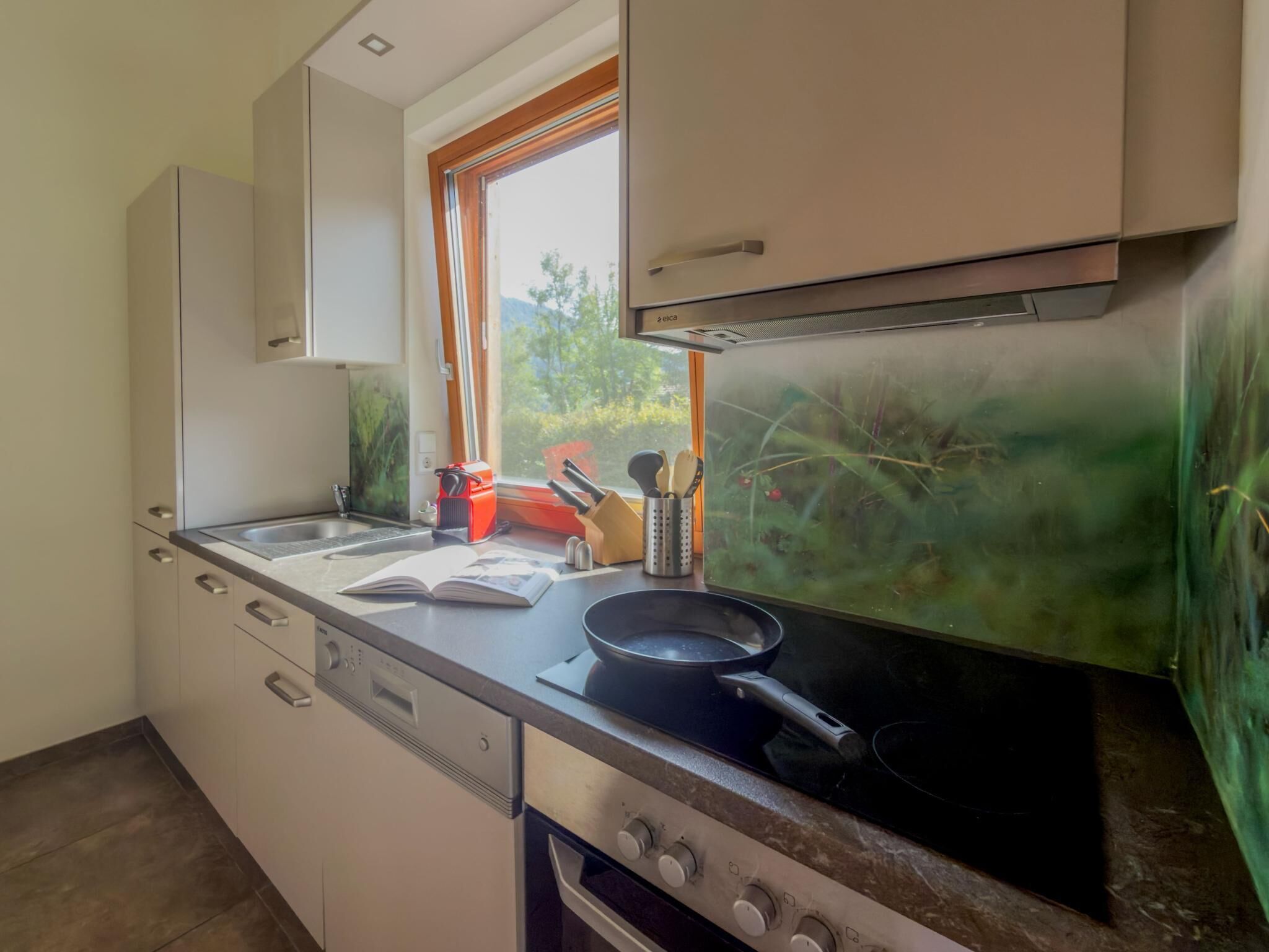 Una cocina compacta con estufa, pileta y alacenas.