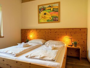 Ein Doppelbett mit weißen Bettwäsche, zwei Nachttische mit Lampen und ein Bild an der Wand.