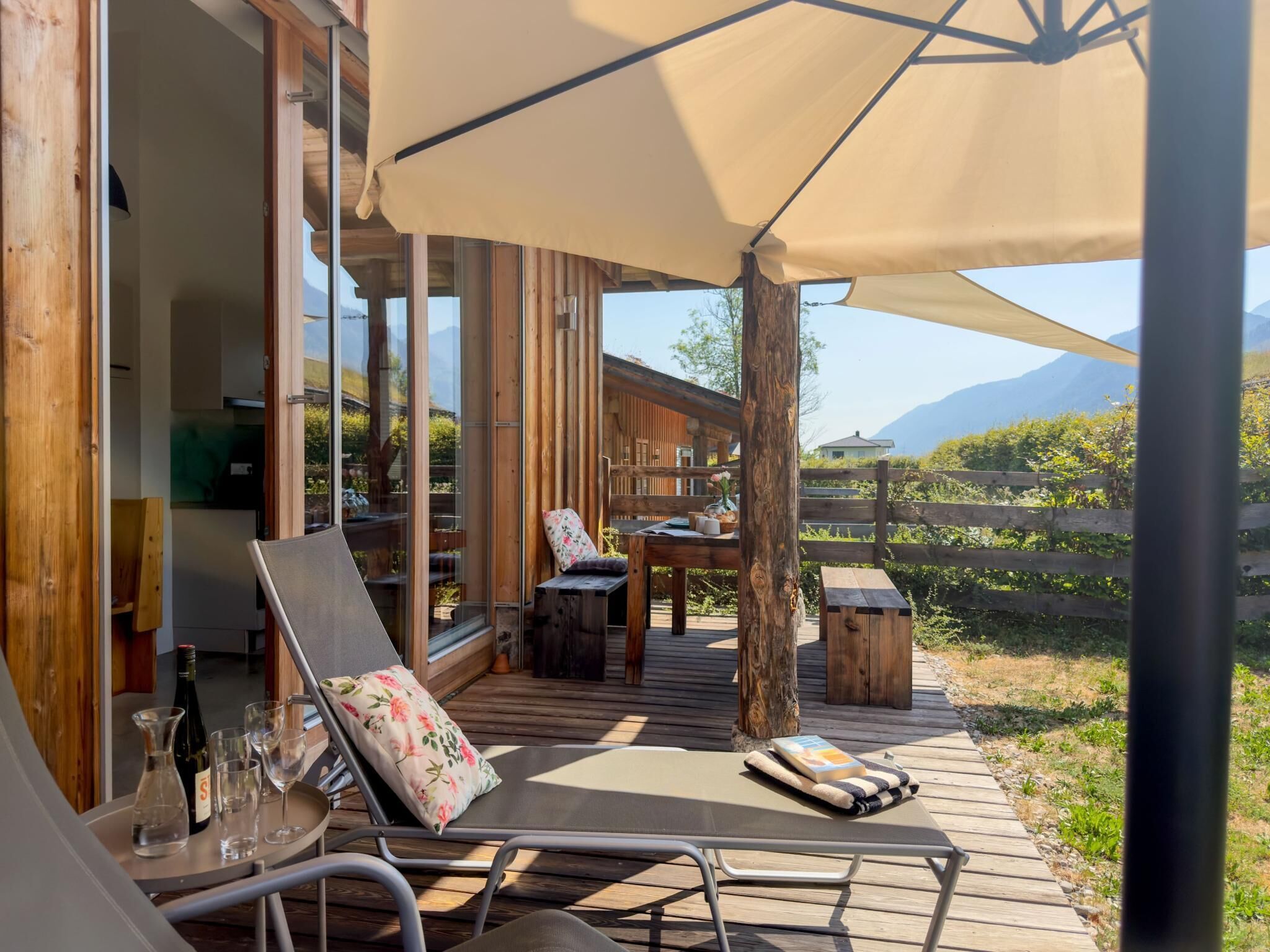 A wooden deck with outdoor furniture, a table, and a chair.