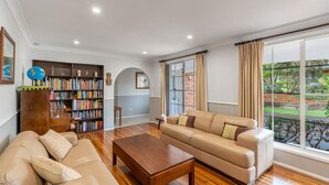 Ein geräumiges Wohnzimmer mit einer Couch, einem Couchtisch und einem Bücherregal voller Bücher.