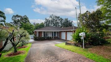 A residential house with a paved driveway, a garage, and a mailbox.
