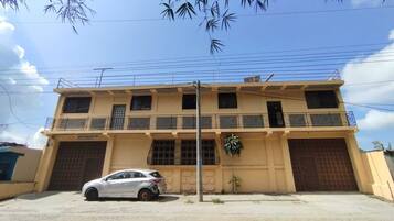 A two-story building with a car parked in front.