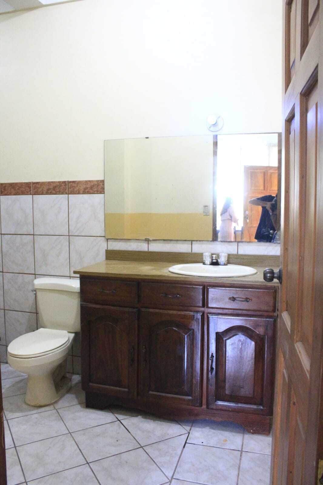 Une salle de bain avec des toilettes, un lavabo et un miroir.