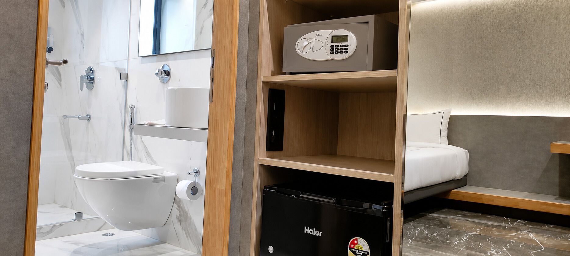 Une petite salle de bain équipée de toilettes, d’un réfrigérateur Haier et d’une étagère sur laquelle se trouve un four à micro-ondes.