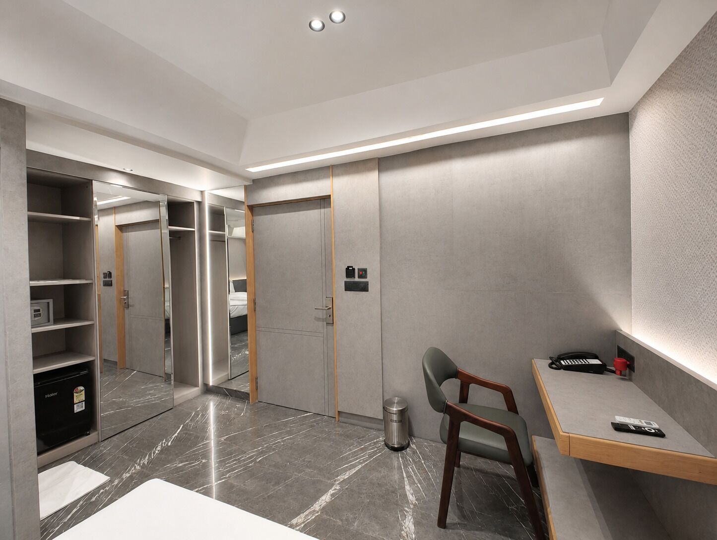 Una habitación de hotel moderna con escritorio, silla y armario.