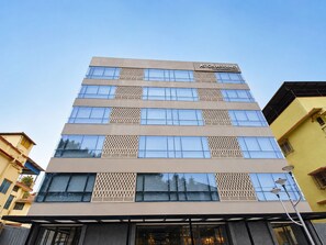 Un edificio de varios pisos con un cartel que dice 'ASTON RESIDENCY BY ASTON PARKS'.