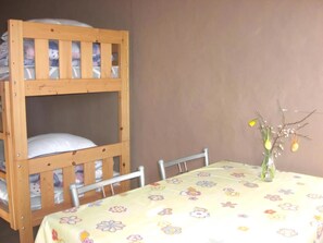 A bunk bed with a floral tablecloth and a vase with flowers.