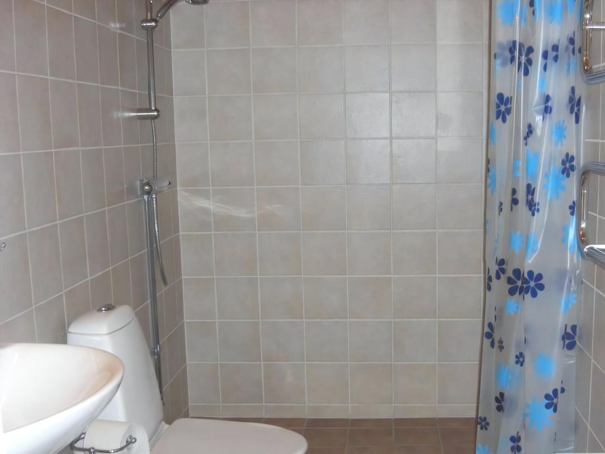 A bathroom with a shower, toilet, and sink.