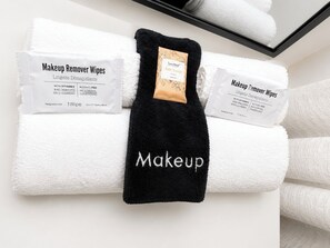 A neatly folded towel with a black cloth labeled 'Makeup' and two white towels with labels 'Makeup Remover Wipes' and 'Bar Soap.' - The Monroe Boutique Near Downtown (Atlanta)