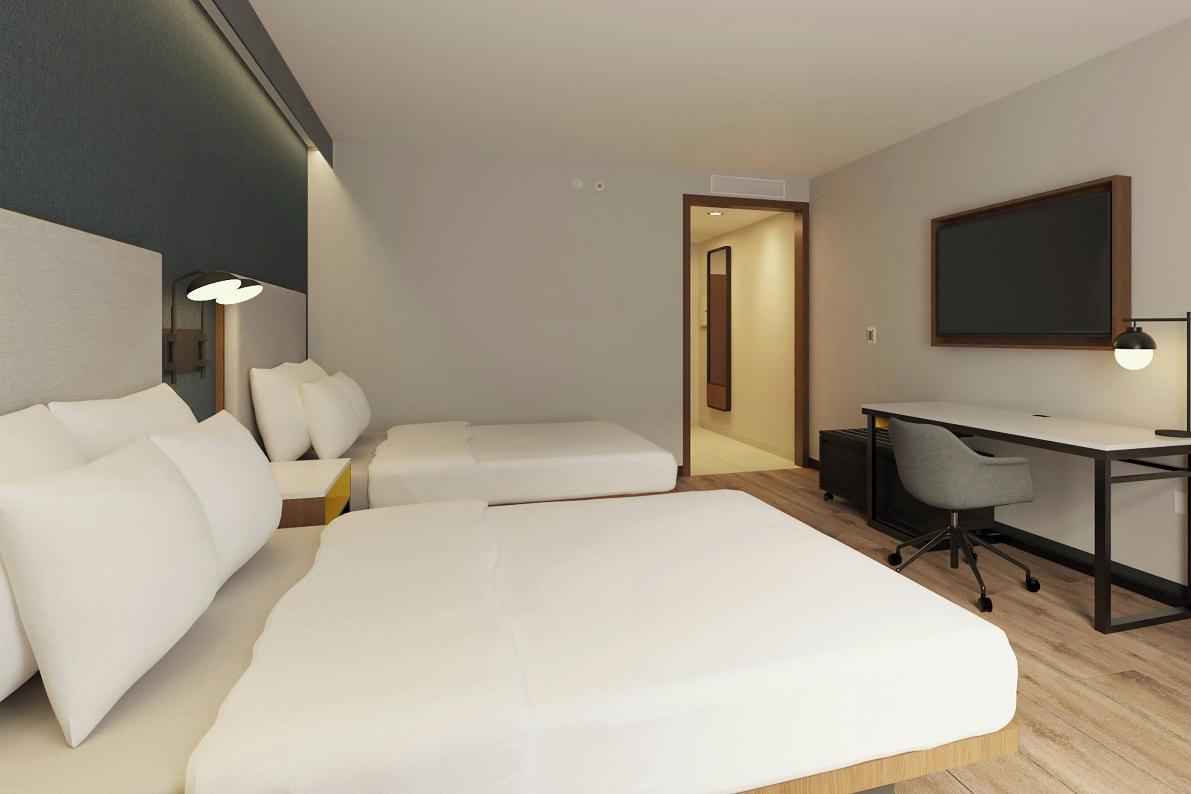 Una habitación de hotel moderna con una cama grande, un escritorio y una silla.