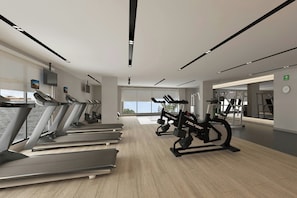 Un gimnasio moderno con cintas de correr, elípticas y máquinas de pesas.