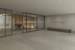 Un intérieur moderne avec des cloisons en verre, un banc et un mur sur lequel on peut lire l’inscription « COURTYARD RV MADDITT ».