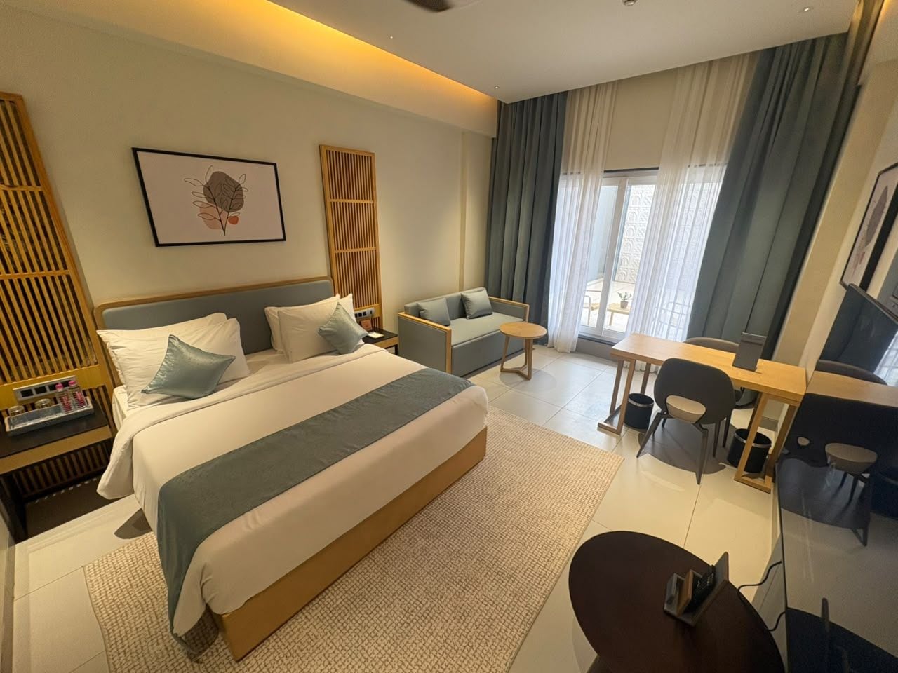 Ein Hotelzimmer mit einem großen Bett, einem Schreibtisch, einem Sessel und einer Couch.
